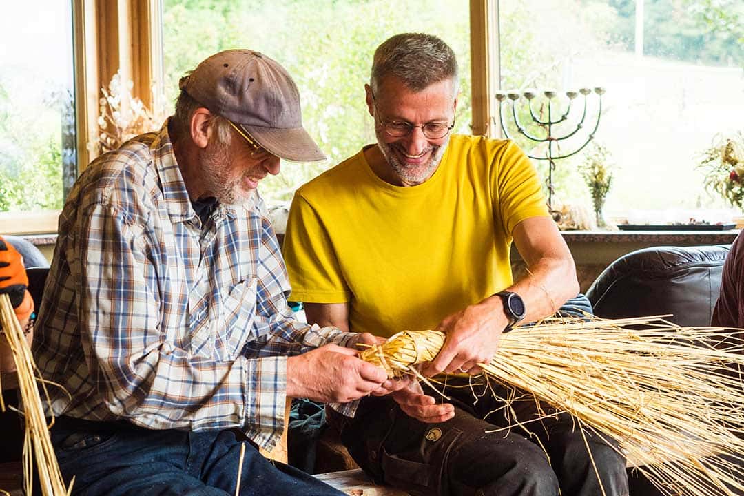 Impressionen aus dem letzten Flechtkurs – Rob van Hernen, der Korbflechtmeister, zeigt einem Teilnehmer die richtige Technik. 